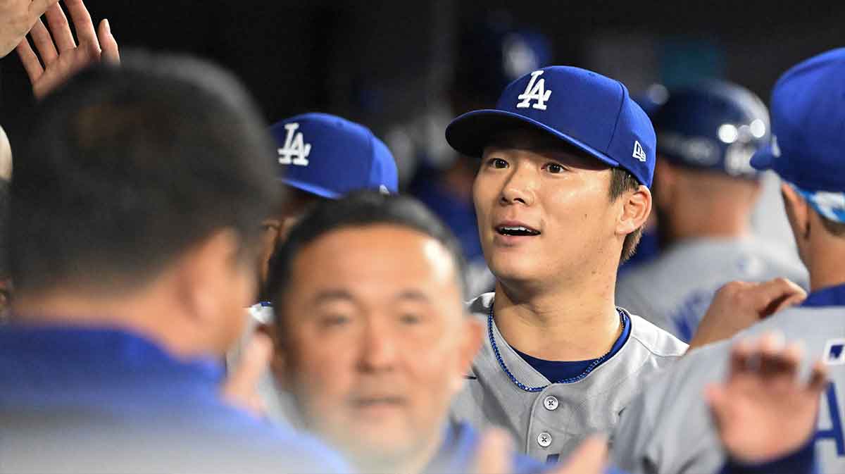Los Angeles Dodgers pitcher Yoshinobu Yamamoto (18) celebrates in the dugout after throwing against the Toronto Blue Jays in the first inning during game two of the 2025 MLB World Series at Rogers Centre.