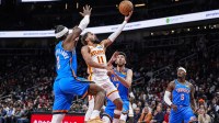 Atlanta Hawks guard Trae Young (11) goes to the basket between Oklahoma City Thunder guard Shai Gilgeous-Alexander (2) and center Chet Holmgren (7) during the first half at State Farm Arena.