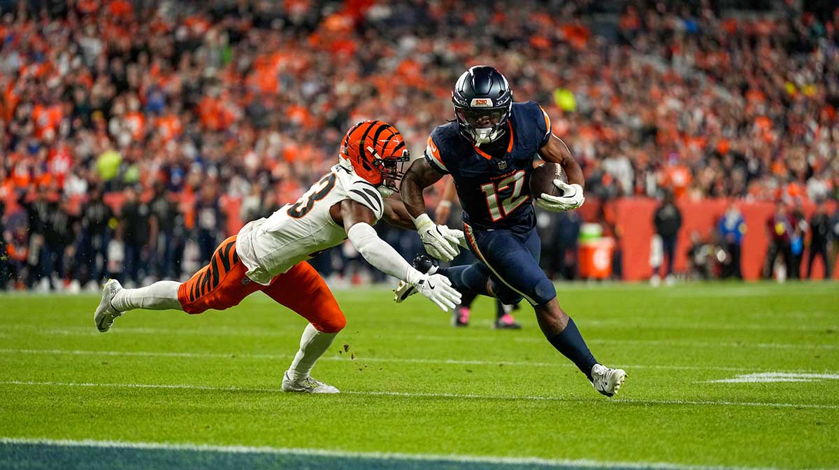 Denver Broncos running back RJ Harvey (12) runs the ball before being pulled down by Cincinnati Bengals cornerback Dax Hill (23)