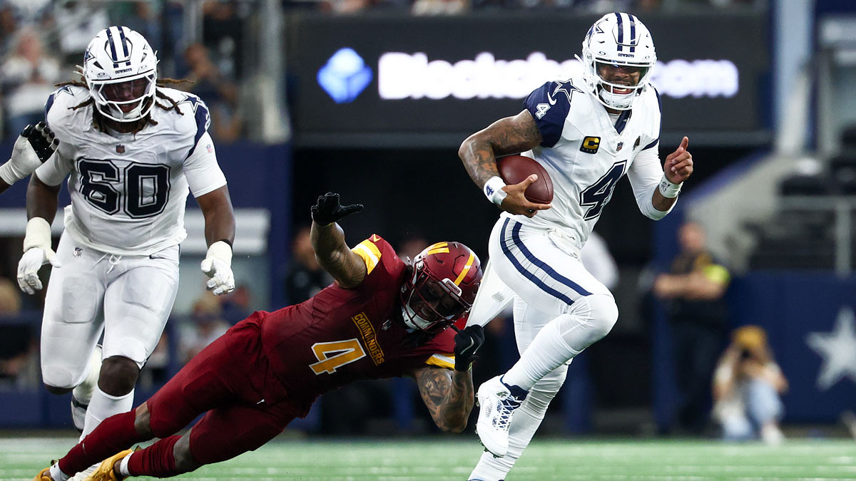 Washington Commanders linebacker Frankie Luvu (4) attempts to tackle Dallas Cowboys quarterback Dak Prescott (4) during the second quarter of the game at AT&T Stadium.