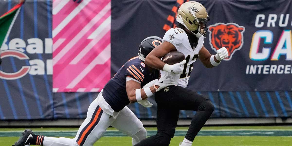 New Orleans Saints wide receiver Chris Olave (12) runs with the ball after making a catch against Chicago Bears cornerback Kyler Gordon (6) during the first half at Soldier Field.