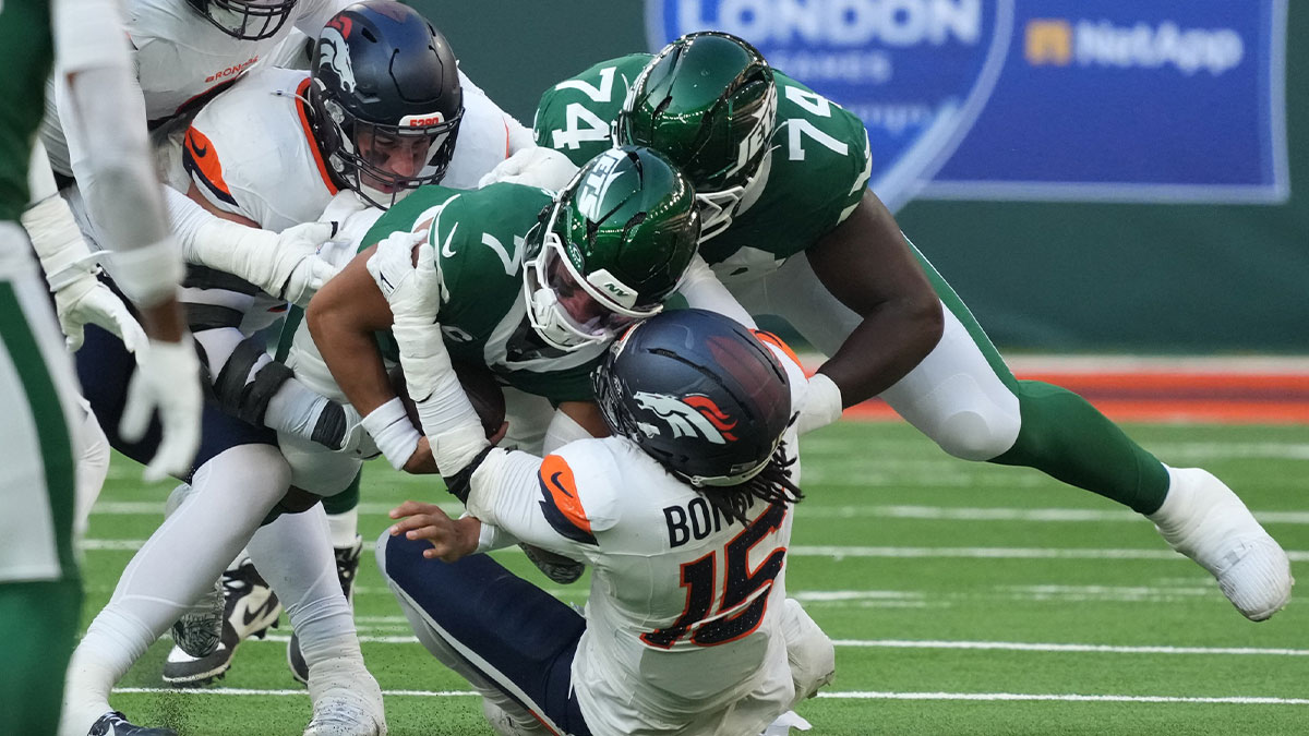 New York Jets quarterback Justin Fields (7) is tackled by Denver Broncos linebacker Nik Bonitto (15) during an NFL International Series game at Tottenham Hotspur Stadium.