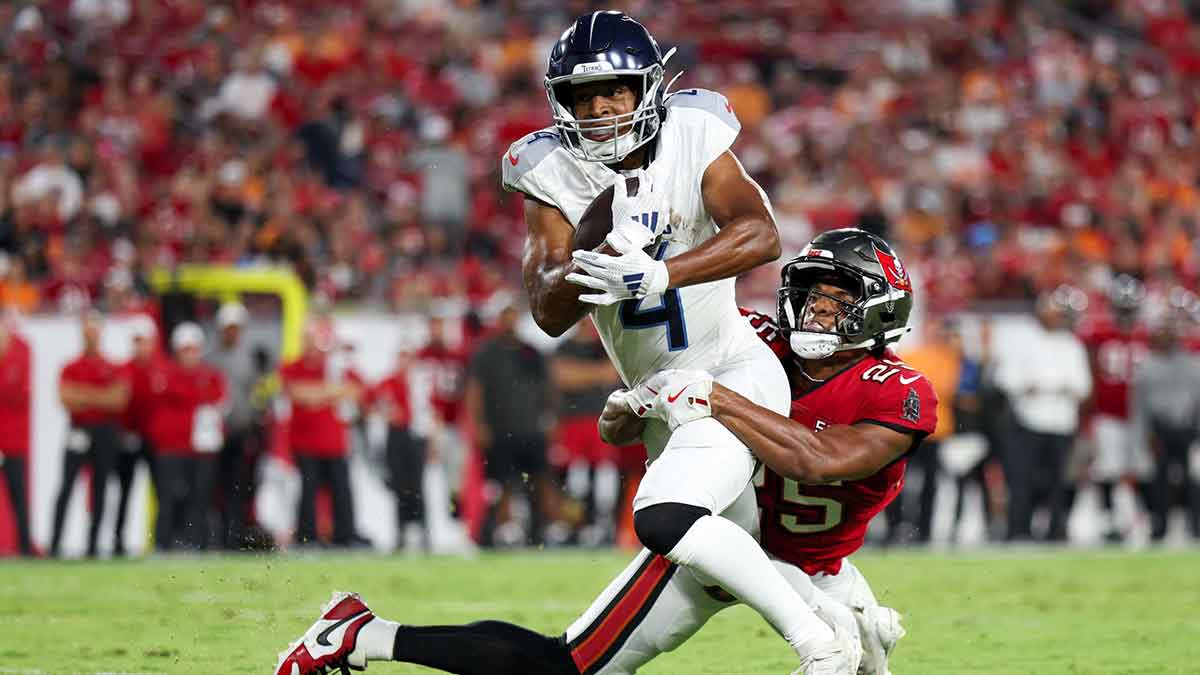 Aug 9, 2025; Tampa, Florida, USA; Tennessee Titans wide receiver Tyler Lockett (4) is brought down by Tampa Bay Buccaneers cornerback Jacob Parrish (25) in the second quarter during a preseason game at Raymond James Stadium. Mandatory Credit: Nathan Ray Seebeck-Imagn Images