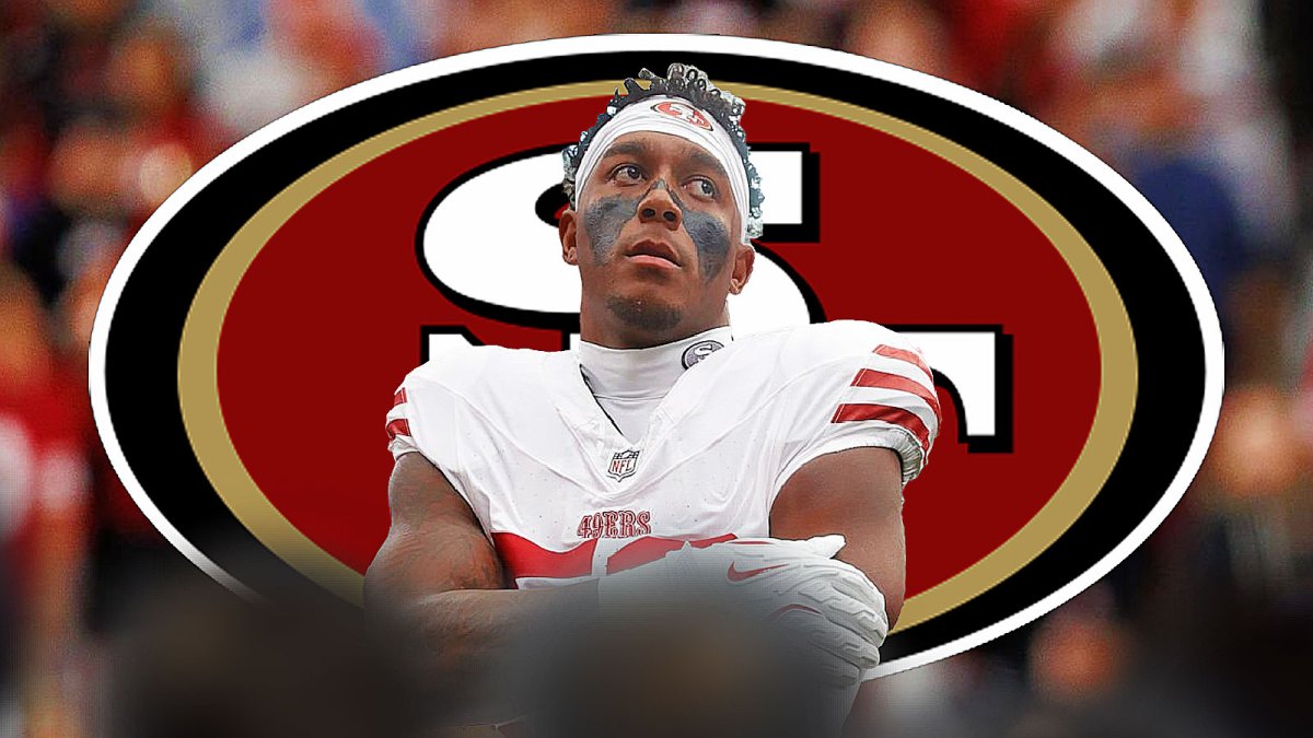 Dee Winters with 49ers logo behind him.