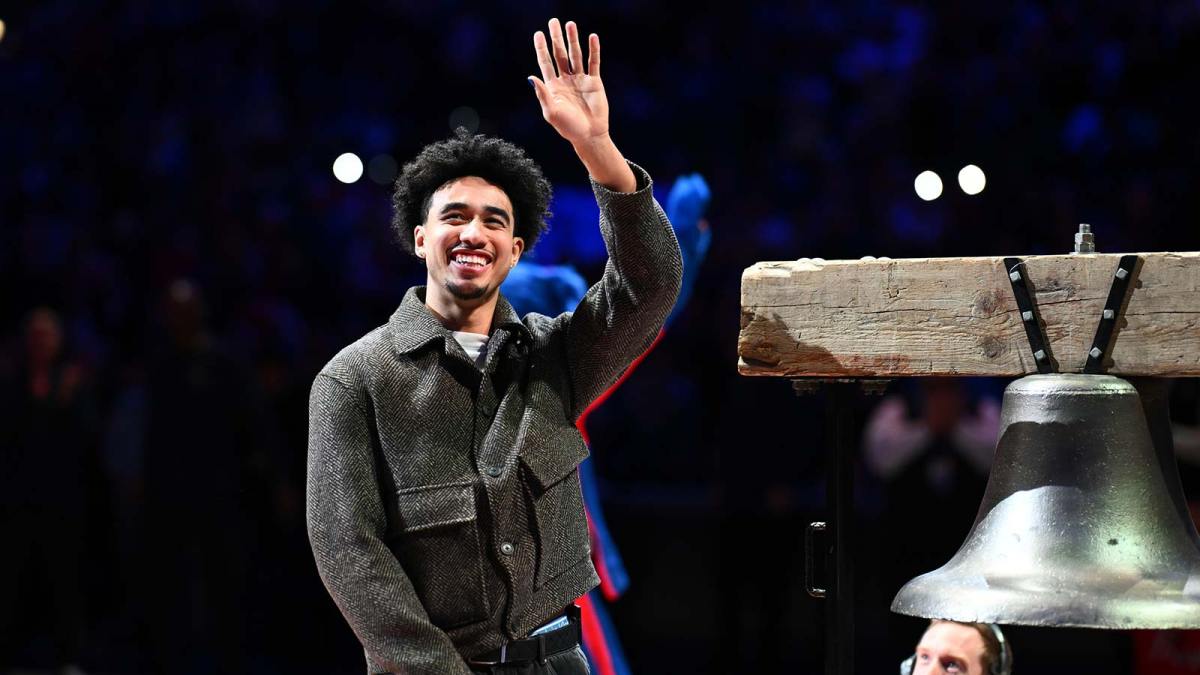 76ers guard Jared McCain smiles beside bell