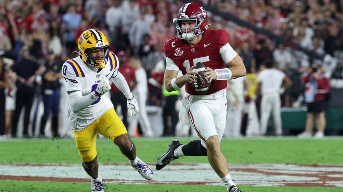Alabama Crimson Tide quarterback Ty Simpson (15) scrambles with the ball defended by Louisiana State Tigers safety Tamarcus Cooley (0) during the first quarter of the game at Saban Field at Bryant-Denny Stadium.