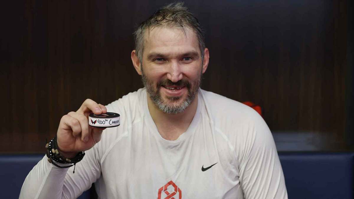 Washington Capitals left wing Alex Ovechkin holds the puck from his 900th NHL goal after the Capitals' game against the St. Louis Blues at Capital One Arena.