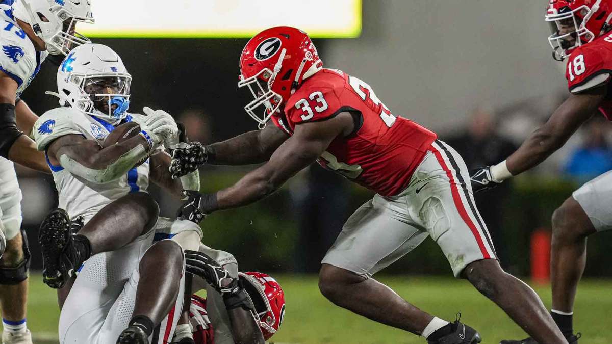 Kentucky Wildcats running back Ray Davis (1) is tackled by Georgia Bulldogs defensive lineman Jonathan Jefferson (94) and linebacker C.J. Allen (33) during the second half at Sanford Stadium.
