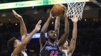 Miami Heat forward Andrew Wiggins (22) shoots between Golden State Warriors forward Trayce Jackson-Davis (32) and forward Gui Santos (15) during the second half at Kaseya Center.