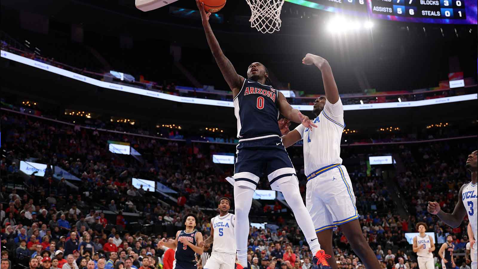 Arizona Wildcats guard Jaden Bradley (0) goes to the basket against UCLA Bruins center Xavier Booker (1) during the first half of the Hall of Fame Series game at Intuit Dome.