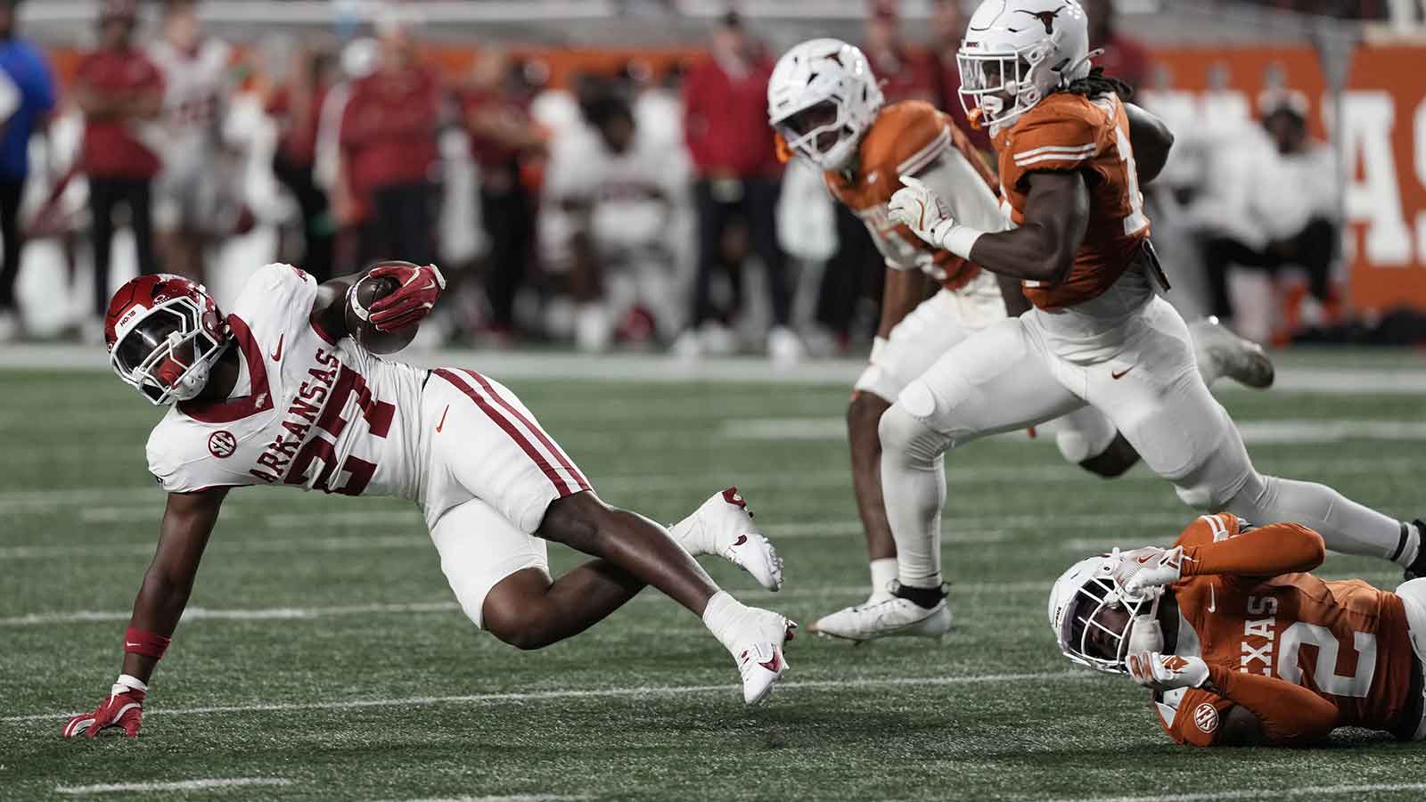 Arkansas Razorbacks running back Cam Settles (27) falls to the ground after being tackled by Texas Longhorns defensive back Derek Williams Jr (2) during the second half at Darrell K Royal-Texas Memorial Stadium.