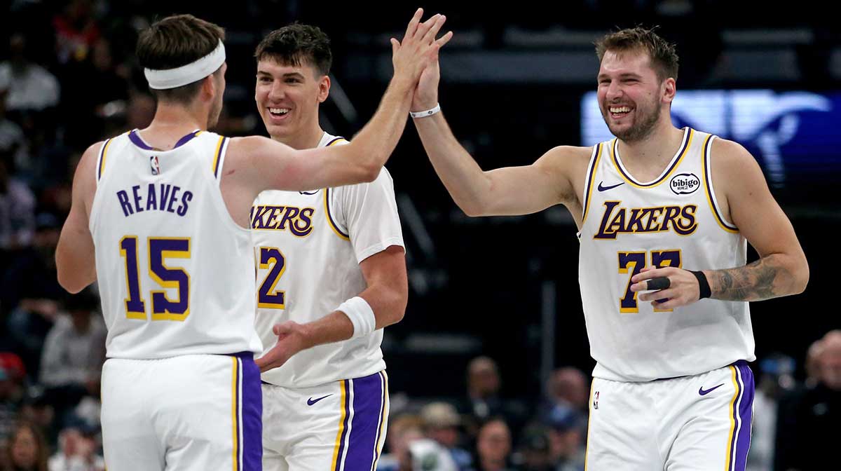 Los Angeles Lakers guard Luka Doncic (77) reacts with guard Austin Reaves (15) during a timeout during the second quarter against the Memphis Grizzlies at FedExForum.