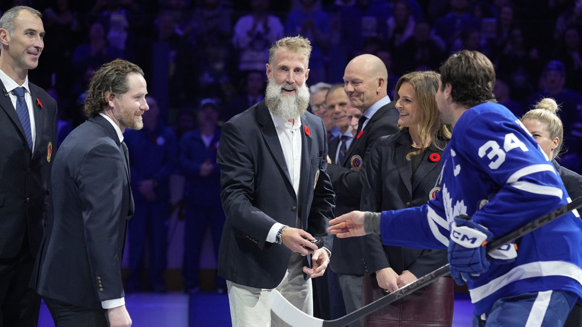 Hockey Hall of Fame inductee Joe Thornton reacts as Toronto Maple Leafs forward Auston Matthews (34) hands him the ceremonial puck as other Hall of Famers Zdeno Chara, Duncan Keith, Matts Sundin, and Jennifer Botteril (left to right) look on before the start of the game against the Carolina Hurricanes at Scotiabank Arena.