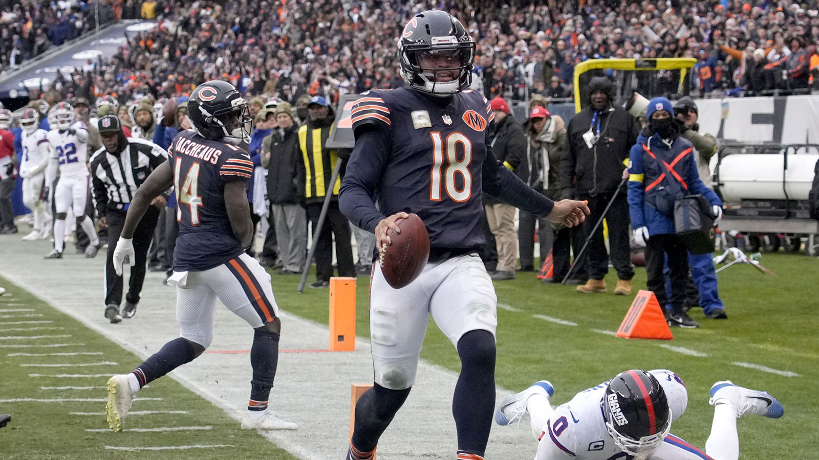 Chicago Bears quarterback Caleb Williams (18) scores the game-winning touchdown against New York Giants linebacker Brian Burns (0) during the fourth quarter at Soldier Field.