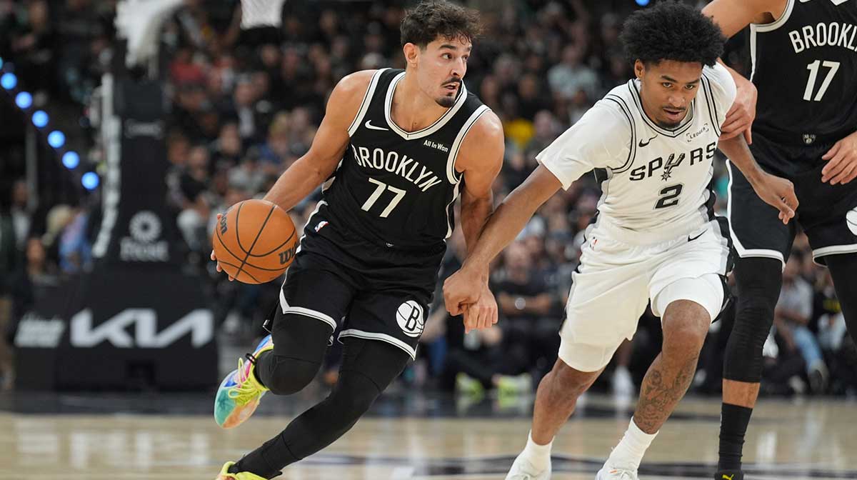 Oct 26, 2025; San Antonio, Texas, USA; Brooklyn Nets guard Ben Saraf (77) dribbles against San Antonio Spurs guard Dylan Harper (2) in the first half at Frost Bank Center. Mandatory Credit: Daniel Dunn-Imagn Images