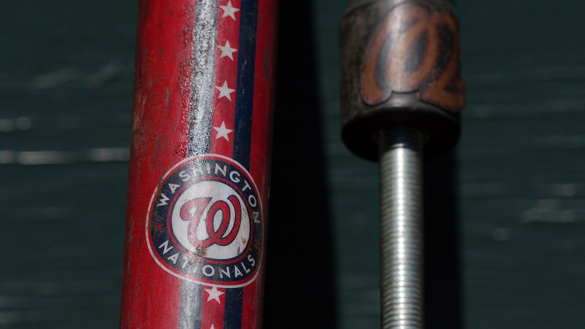 The Washington Nationals logo appears on a fungo bat in the dugout before the game against the San Francisco Giants at Oracle Park.