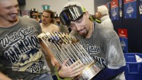Los Angeles Dodgers pitcher Blake Snell (7) celebrates with the Commissioner's Trophy in the locker room after defeating the Toronto Blue Jays in the 2025 MLB World Series at Rogers Centre.