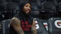 Trail Blazers guard Damian Lillard (0) watches teammates warm up before a game against the Los Angeles Lakers at Moda Center