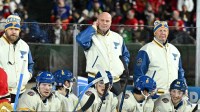 St. Louis Blues head coach Jim Montgomery, center, watches play against the Chicago Blackhawks during the third period in the Winter Classic at Wrigley Field.