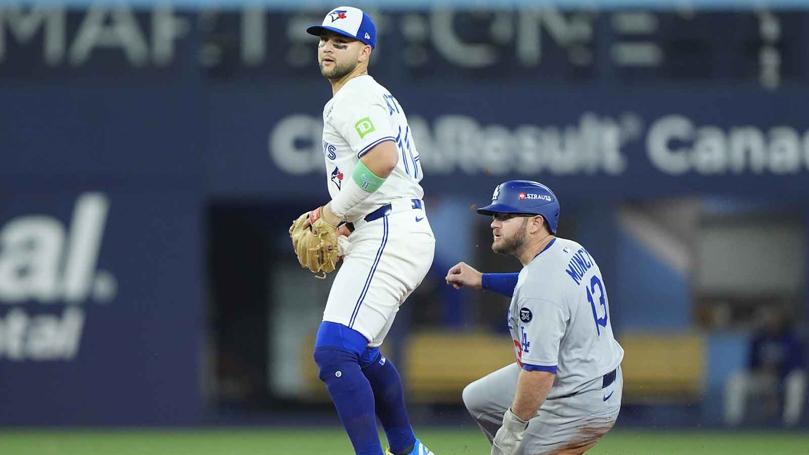 Los Angeles Dodgers third baseman Max Muncy (13) is out against Toronto Blue Jays designated hitter Bo Bichette (11) in the sixth inning during game seven of the 2025 MLB World Series at Rogers Centre.