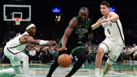 Boston Celtics guard Jaylen Brown (7) controls the ball between Brooklyn Nets guard Terance Mann (14) and guard Egor Demin (8) during the second half at TD Garden.