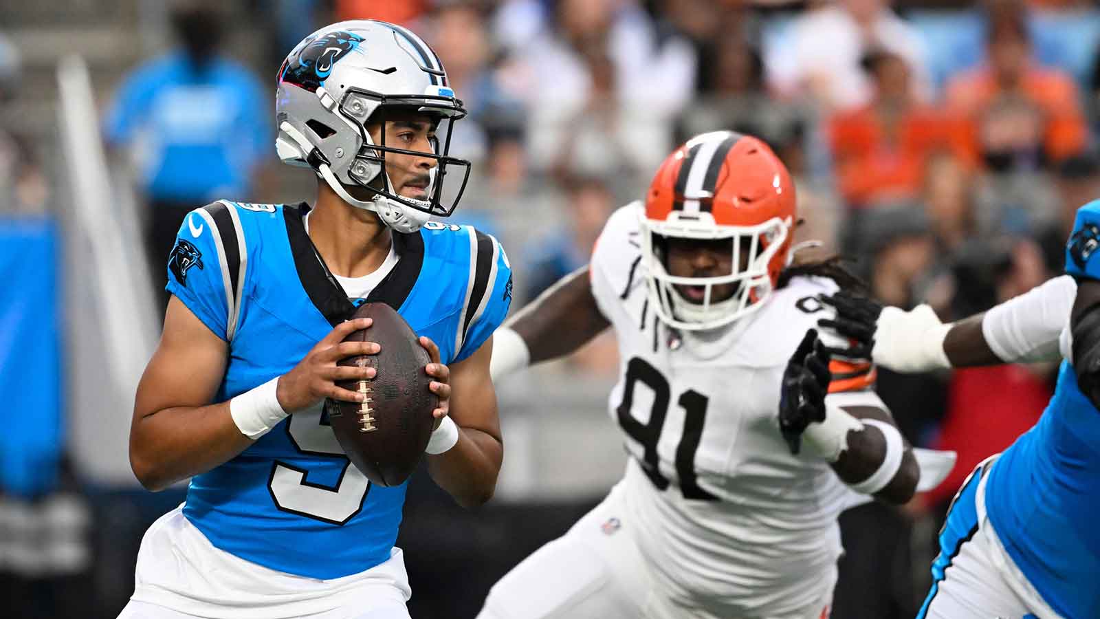 Carolina Panthers quarterback Bryce Young (9) looks to pass as Cleveland Browns defensive end Alex Wright (91) pressures in the first quarter at Bank of America Stadium.