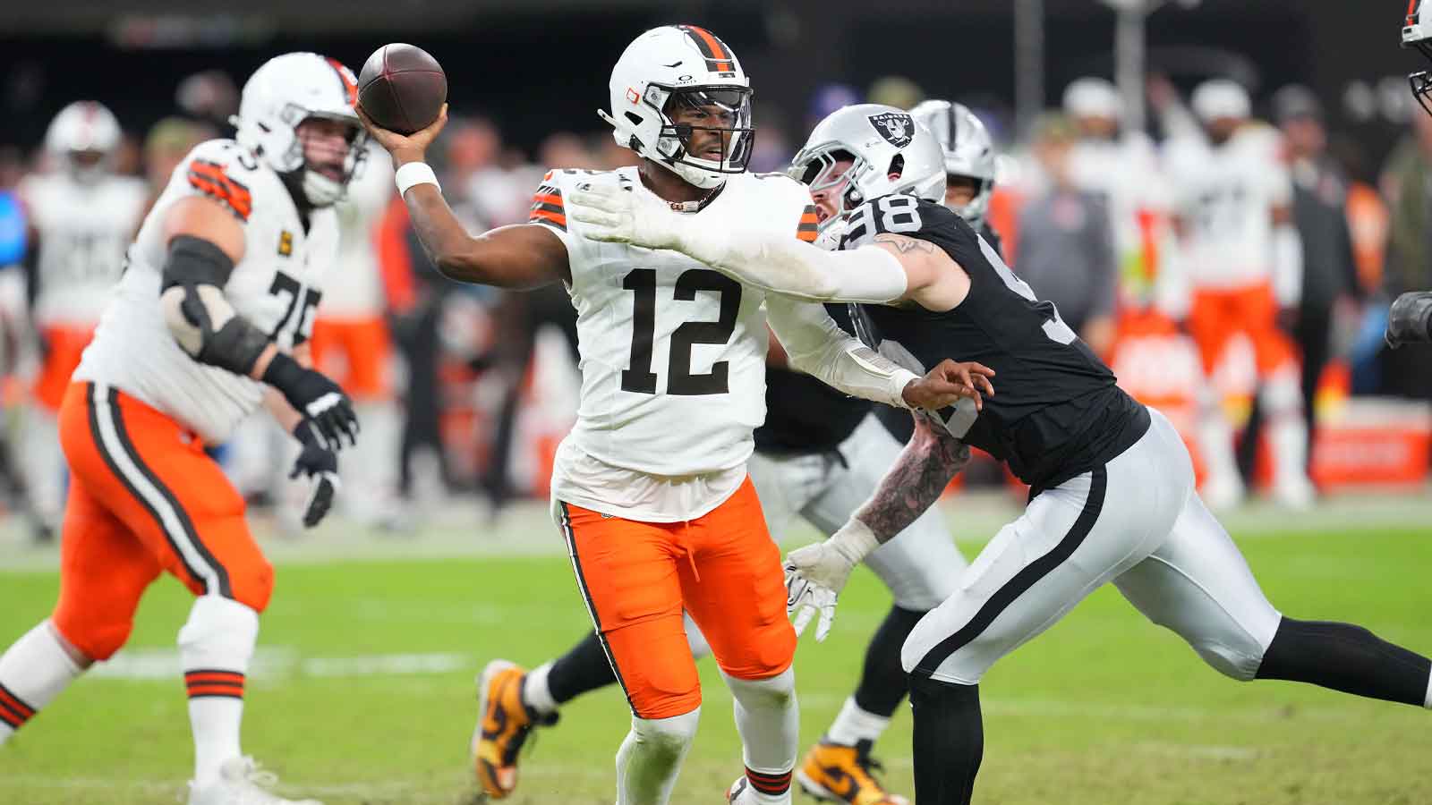 Cleveland Browns quarterback Shedeur Sanders (12) looks to make a pass attempt as Las Vegas Raiders defensive end Maxx Crosby (98) tackles him during the third quarter at Allegiant Stadium.