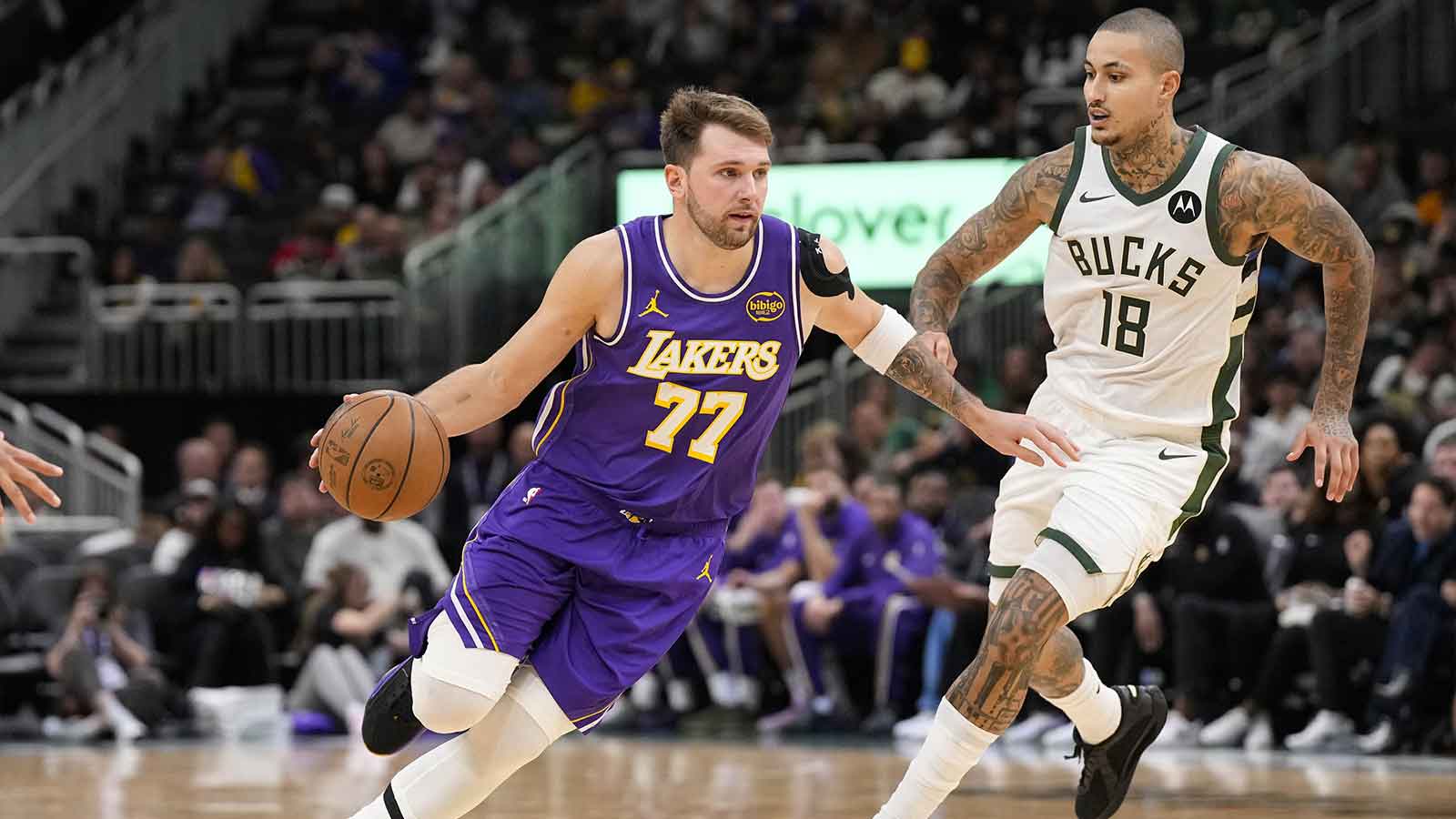 Los Angeles Lakers guard Luka Doncic (77) drives towards the basket around Milwaukee Bucks forward Kyle Kuzma (18) during the third quarter at Fiserv Forum.