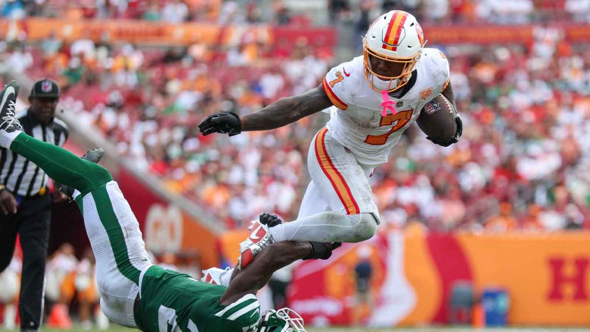 Tampa Bay Buccaneers running back Bucky Irving (7) is tripped up by New York Jets cornerback Brandon Stephens (21) in the third quarter at Raymond James Stadium.