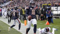 Chicago Bears quarterback Caleb Williams (18) scores the game-winning touchdown against New York Giants linebacker Brian Burns (0) during the fourth quarter at Soldier Field.