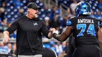 Detroit Lions head coach Dan Campbell fist bumps guard Kayode Awosika (74) during warmup ahead of the New York Giants game at Ford Field in Detroit on Sunday, Nov. 23, 2025.
