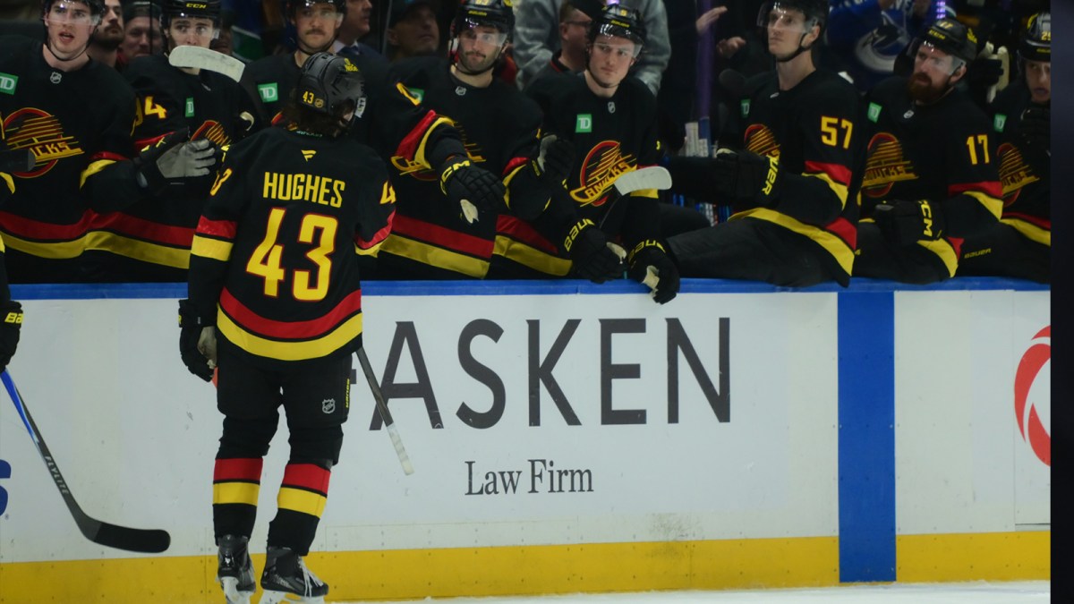 Vancouver Canucks defenseman Quinn Hughes (43) celebrates scoring with teammates on the bench during the third period against the Calgary Flames at Rogers Arena.