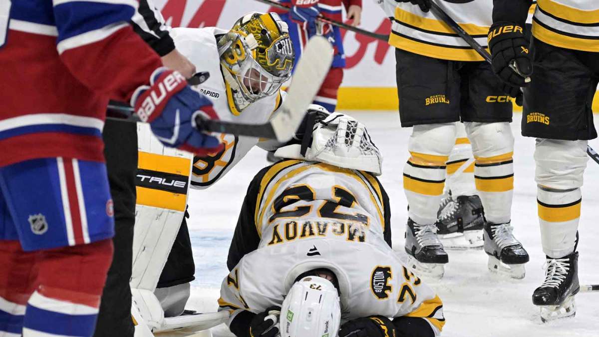 Boston Bruins goalie Jeremy Swayman (1) checks on teammate Boston Bruins defenseman Charlie McAvoy (73) who got hit by a shot in the face during the second period of the game against the Montreal Canadiens at the Bell Centre.