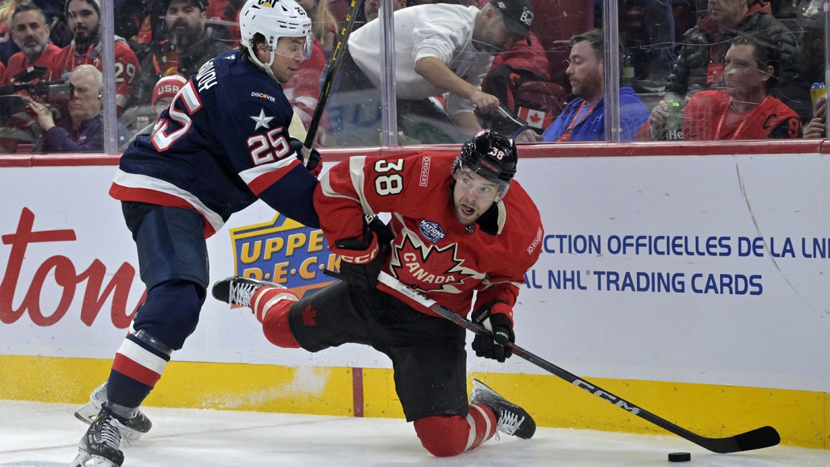 Team Canada forward brandon Hagel (38) plays the puck and Team United States defenseman Charlie McAvoy (25) defends in the second period during a 4 Nations Face-Off ice hockey game at the Bell Centre.
