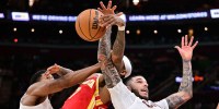 Cleveland Cavaliers forward De'Andre Hunter (12) and guard Lonzo Ball (2) go for a rebound against Atlanta Hawks guard Nickeil Alexander-Walker (7) during the second half at Rocket Arena.