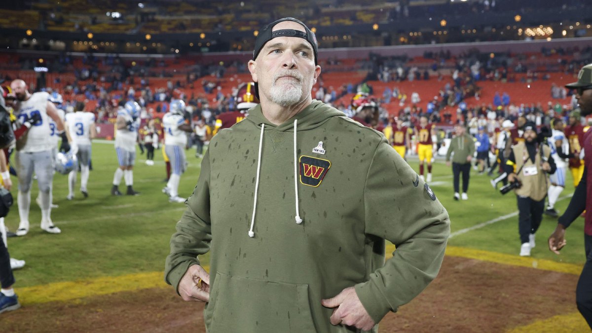 Washington Commanders head coach Dan Quinn stands on the field following a loss to the Detroit Lions at Northwest Stadium.