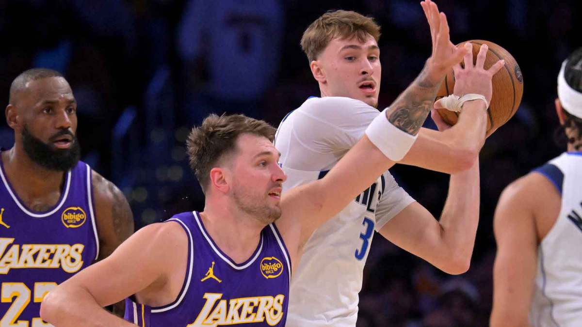 Dallas Mavericks forward Cooper Flagg (32) is defended by Los Angeles Lakers guard Luka Doncic (77) in the first half at Crypto.com Arena.