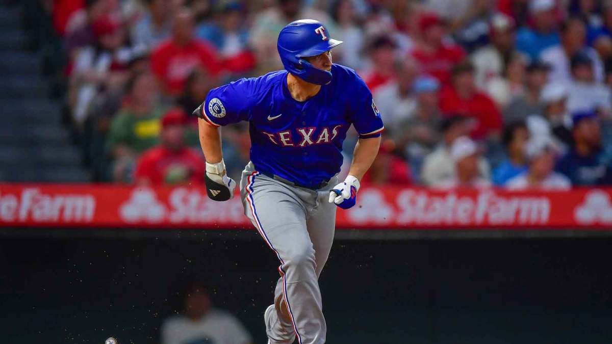 Texas Rangers shortstop Corey Seager (5) reaches first on a fielding error by Los Angeles Angels center fielder Jo Adell (7) during the sixth inning at Angel Stadium.