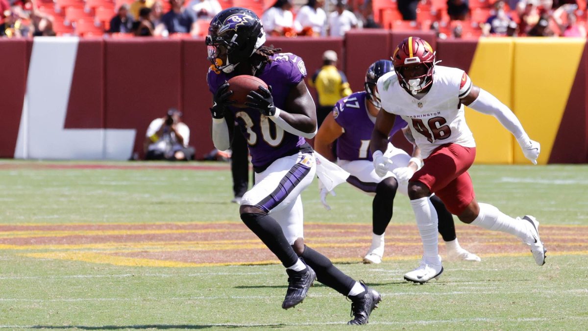 Baltimore Ravens running back D'Ernest Johnson (30) runs with the ball ahead of Washington Commanders linebacker Kam Arnold (46) in the fourth quarter at Northwest Stadium.