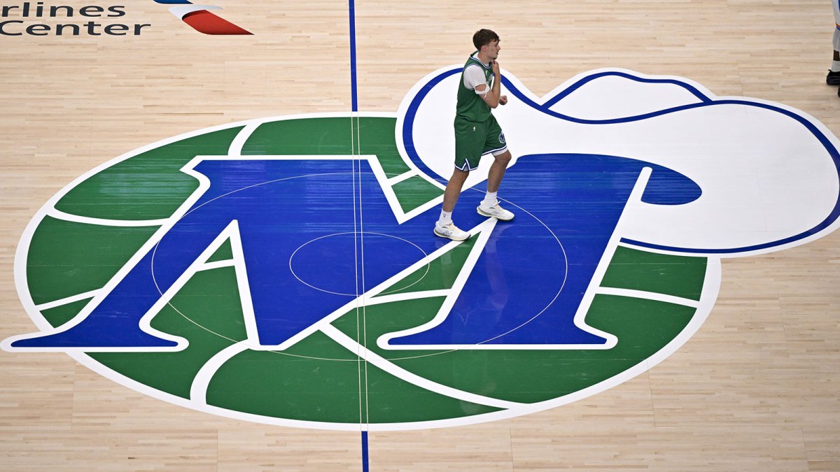 Dallas Mavericks forward Cooper Flagg (32) looks on from center court on the Mavericks logo during the first quarter against the Oklahoma City Thunder at the American Airlines Center.