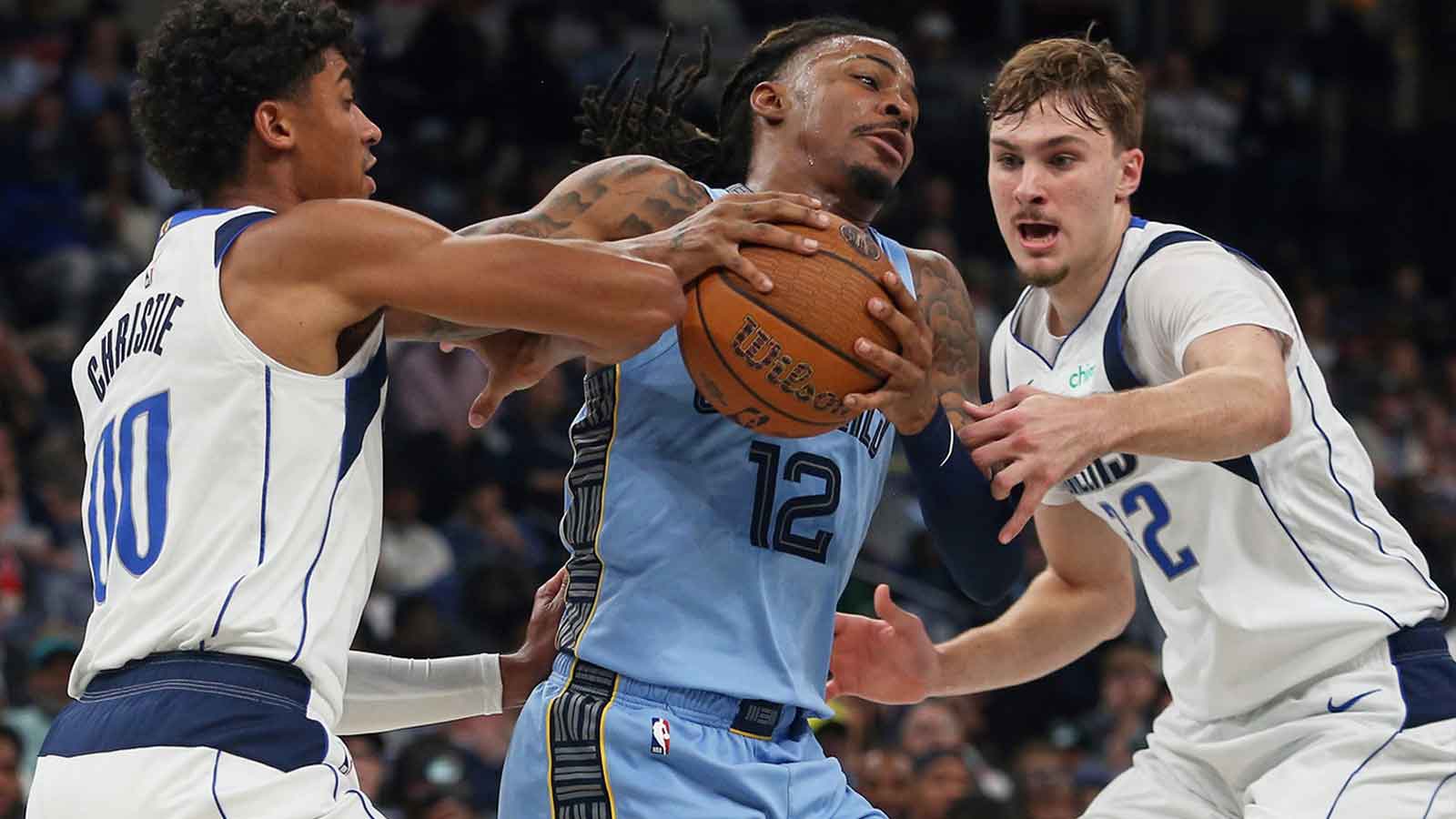 Memphis Grizzlies guard Ja Morant (12) drives to the basket against Dallas Mavericks guard Max Christie (00) and forward Cooper Flagg (32) during the second quarter at FedExForum.