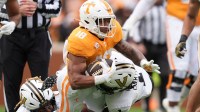 Tennessee running back DeSean Bishop (18) is brought down by Vanderbilt safety CJ Heard (8) and Vanderbilt safety Dontae Carter (1) during an NCAA college football game on Nov. 29, 2025, in Knoxville, Tennessee.