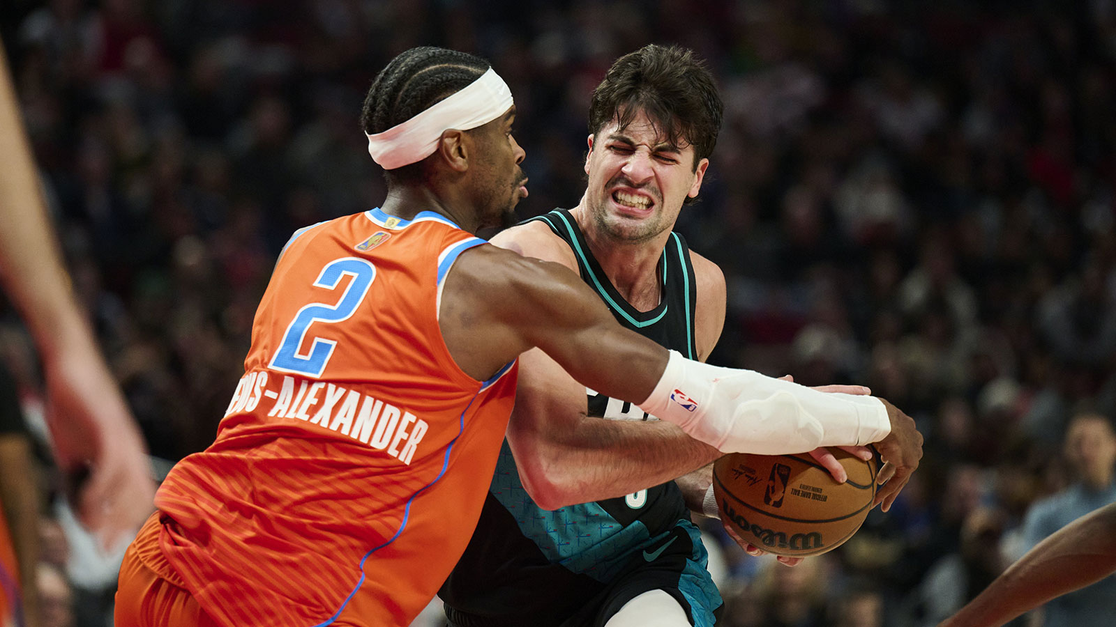 Portland Trail Blazers forward Deni Avdija (8) is fouled by Oklahoma City Thunder guard Shai Gilgeous-Alexander (2) as he drives to the basket during the second half at Moda Center.
