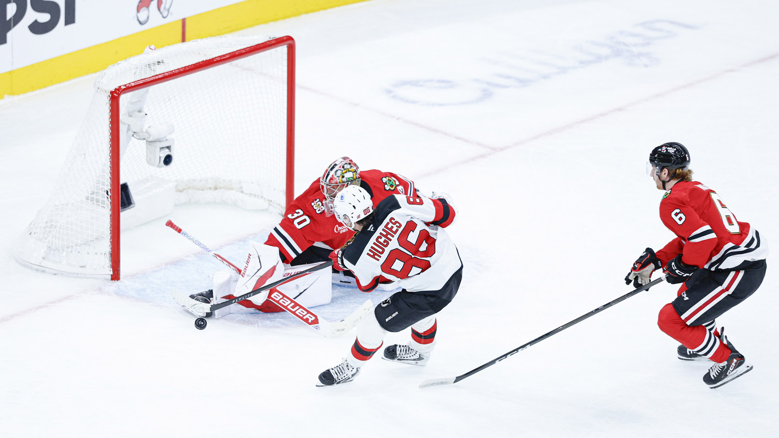 Chicago Blackhawks goaltender Spencer Knight (30) defends against New Jersey Devils center Jack Hughes (86) during the second period at United Center.