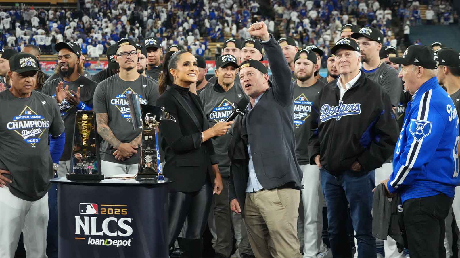 Los Angeles Dodgers president of baseball operations Andrew Friedman is interviewed by TBS reporter Lauren Shehadi as owner Mark Walter and president Stan Kasten watch after game four of the NLCS round for the 2025 MLB playoffs against the Milwaukee Brewers at Dodger Stadium.