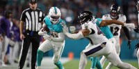 Miami Dolphins running back De'Von Achane (28) is pushed out of bounds by Baltimore Ravens long snapper Nick Moore (46) during the second quarter at Hard Rock Stadium.