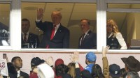 President Donald Trump waves during the second quarter of a game between the Washington Commanders and the Detroit Lions at Northwest Stadium.