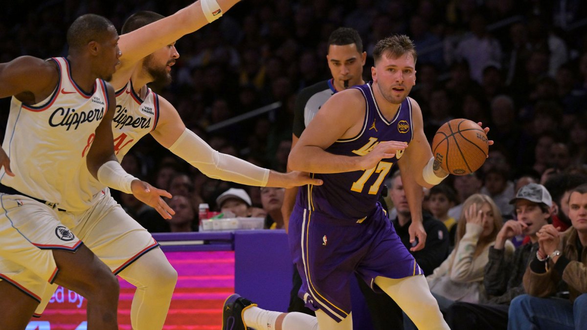 Los Angeles Lakers guard Luka Doncic (77) drives past Los Angeles Clippers guard Kris Dunn (8) and center Ivica Zubac (40) during the first half at Crypto.com Arena.