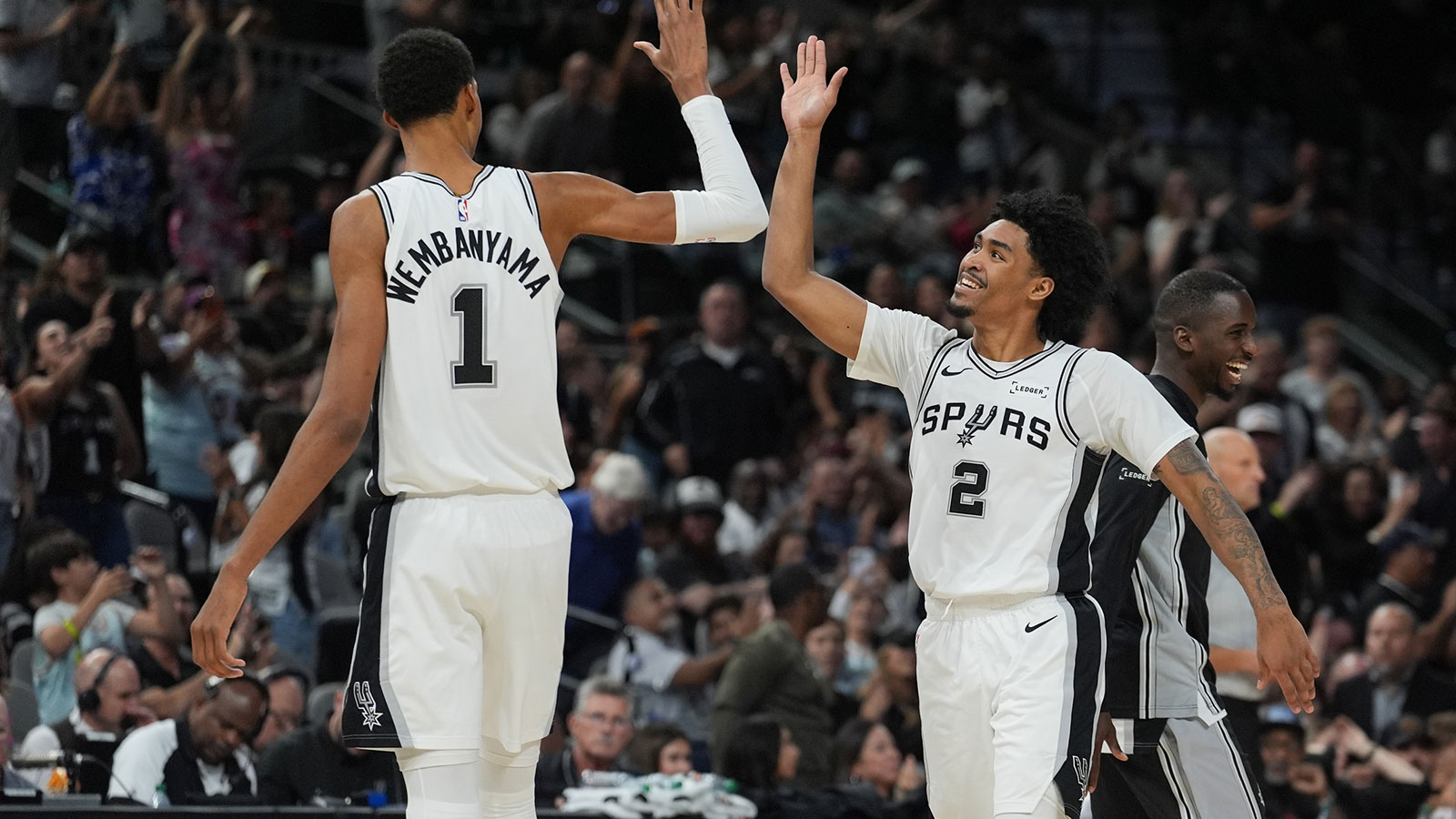 San Antonio Spurs forward Victor Wembanyama (1) and guard Dylan Harper (2) celebrates in the second half against the Brooklyn Nets at Frost Bank Center.