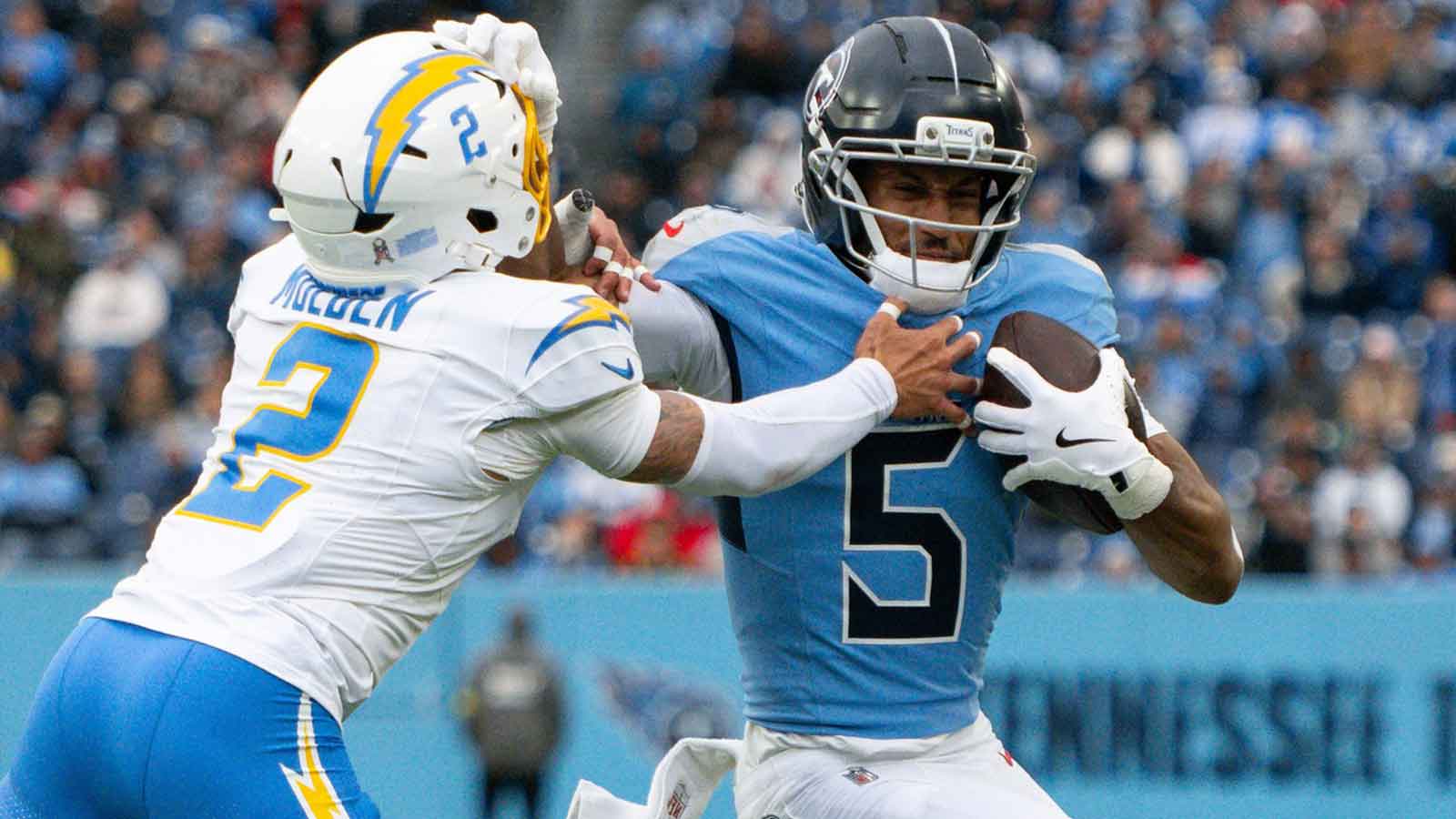 Tennessee Titans wide receiver Elic Ayomanor (5) stiff arms Los Angeles Chargers cornerback Elijah Molden (2) during the first half at Nissan Stadium.